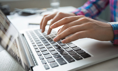 cropped-view-hands-typing-laptop.jpg